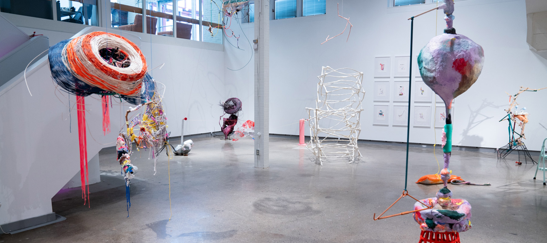 several sculptures, both free-standing and suspended, made of miscellaneous household materials